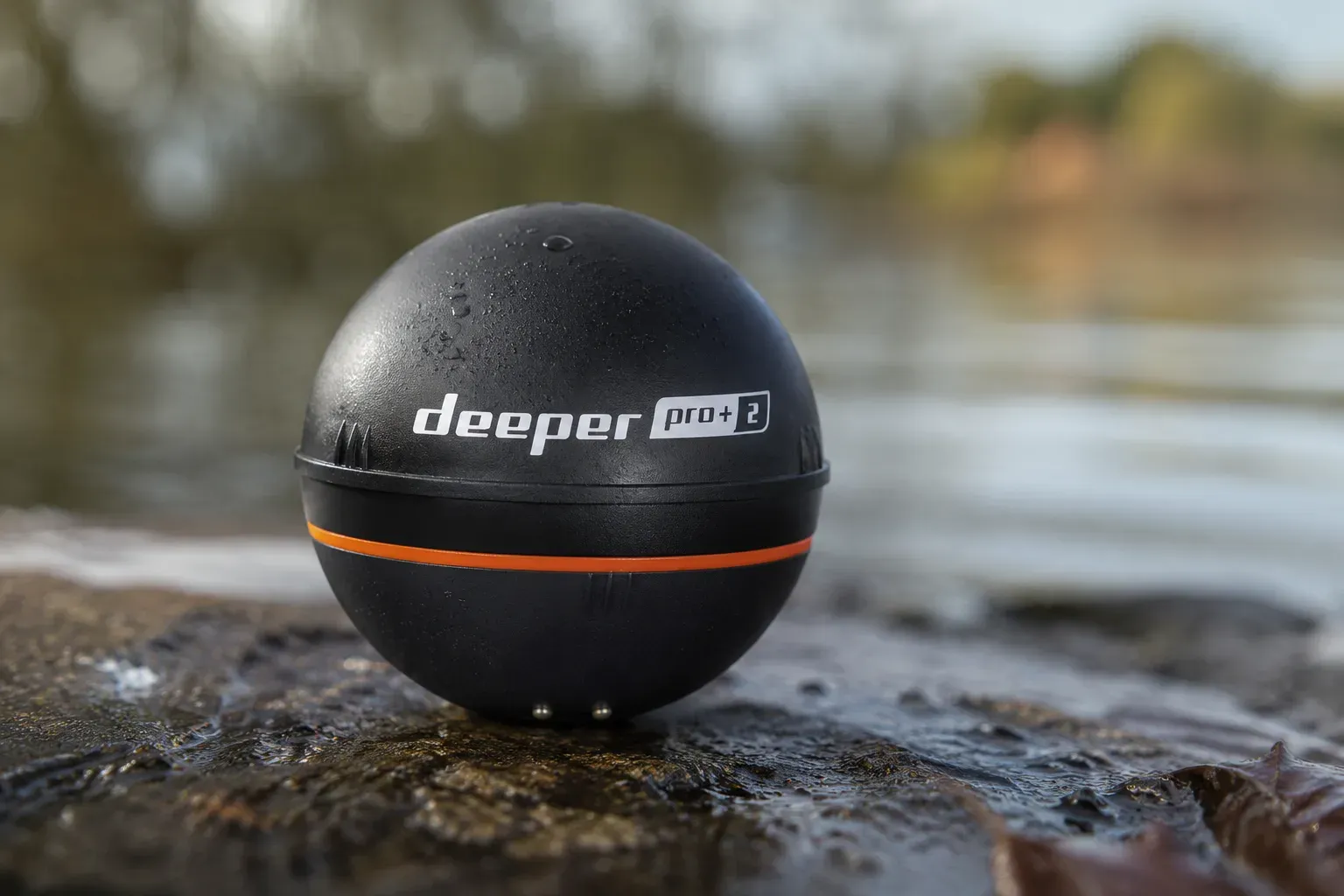 Echosonda Deeper w dłoni wędkarza nad taflą jeziora o świcie